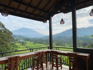 una mesa y sillas en un balcón con vistas en Villa Lumbung Ayu Sari & Spa, en Karangasem