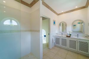 a bathroom with two sinks and a glass shower at Royal Westmoreland - Cassia Heights 14 townhouse in Saint James
