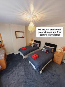 1 Schlafzimmer mit 2 Betten und einem Kronleuchter in der Unterkunft Elegant and central two bedrooms house in Bristol