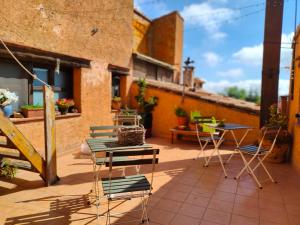 un patio avec des chaises et des tables dans un bâtiment dans l'établissement Cal Tous, La Socarrimada, à Rojals