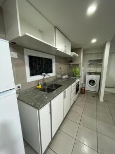 a kitchen with a sink and a stove top oven at Departamento centrico in La Cieneguita