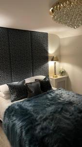 um quarto com uma cama grande e um cobertor preto em 'Cosy Cottage' - 2 Bed - Central Bawtry - Entire Cottage em Bawtry