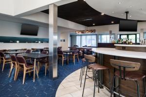 a bar in a restaurant with tables and stools at Courtyard by Marriott Phoenix Airport in Phoenix