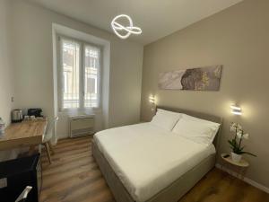 a bedroom with a bed and a desk and a window at Belltower Elegans in Rome
