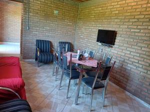 uma sala de jantar com mesa e cadeiras e uma televisão em Casa de Campo Trevão - Queluzito em Conselheiro Lafaiete