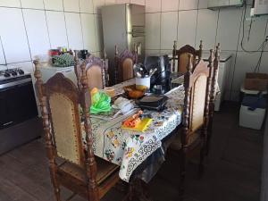 een keuken met een tafel met stoelen en een tafel sidx sidx bij Casa de Campo Trevão - Queluzito in Conselheiro Lafaiete