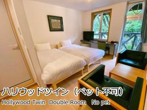 Schlafzimmer mit einem Bett, einem Schreibtisch und einem TV in der Unterkunft Lodge Atelier in Hokuto