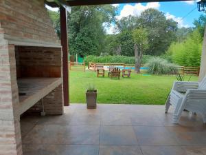 um pátio com uma lareira de tijolos e um quintal em Chalet El Buho em Villa General Belgrano