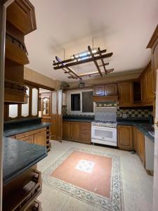 uma cozinha com armários de madeira e um forno com placa de fogão em Elegant Apartment no Cairo