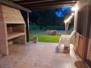 a patio with a chair and a stone fireplace at Chalet El Buho in Villa General Belgrano