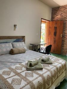 1 dormitorio con 1 cama con toallas en Escarpas do Caraça, en Catas Altas