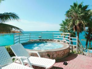 - un bain à remous avec des chaises et l'océan en arrière-plan dans l'établissement Departamento al pie del mar Torre Marina, à Salinas