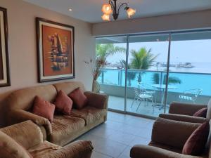 - un salon avec un canapé et une vue sur l'océan dans l'établissement Departamento al pie del mar Torre Marina, à Salinas