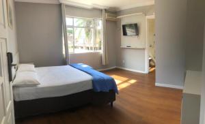 um quarto com uma cama e uma grande janela em MONTE LÍBANO HOTEL II em Florianópolis