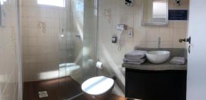 uma casa de banho com um chuveiro, um WC e um lavatório. em MONTE LÍBANO HOTEL II em Florianópolis
