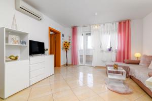 ein Wohnzimmer mit einem Sofa und einem TV in der Unterkunft Apartments with a parking space Liznjan, Medulin - 21802 in Ližnjan