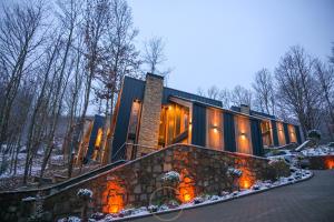 a house with a stone wall in the snow at Holiday Villas in Orllan