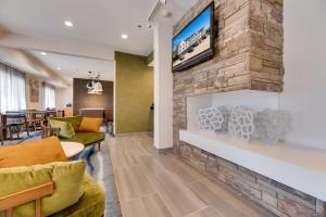 a lobby with a stone fireplace with a tv on a wall at Fairfield Inn & Suites by Marriott Spearfish in Spearfish