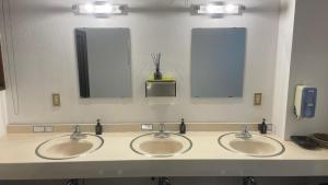 a public bathroom with three sinks and two mirrors at Iimori Vista in Hakuba