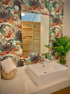 a bathroom with a white sink and a mirror at PUNTA POPY Boutique HOTEL in Las Terrenas