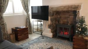 a living room with a fireplace with a tv above it at Ty Cwtch in Dolgellau