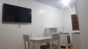 een kamer met een tafel en stoelen en een tv aan de muur bij Casa da Mari in Canela
