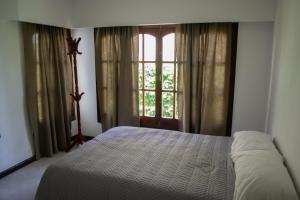 una camera con un letto di fronte a una finestra di Amplio chalet en zona centro a San José