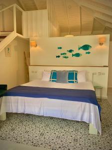 Schlafzimmer mit einem Bett mit Fisch an der Wand in der Unterkunft PUNTA POPY Boutique HOTEL in Las Terrenas