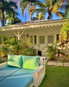 um banco em frente a uma casa com palmeiras em PUNTA POPY Boutique HOTEL em Las Terrenas