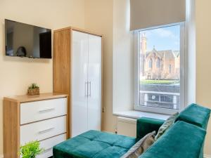 a living room with a couch and a window at Apartment Three - Uk44286 in Arbroath