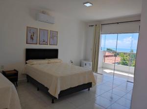 a bedroom with a bed and a large window at Encantu's pousada in Conde +12 photos
