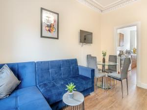 a blue couch in a living room with a table at Apartment Four - Uk44287 in Arbroath