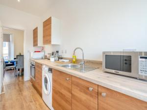 uma cozinha com um lavatório e um micro-ondas em Apartment Four - Uk44287 em Arbroath