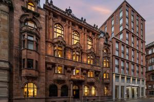 een oud bakstenen gebouw met lichten aan bij AC Hotel by Marriott Glasgow in Glasgow