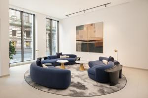 a living room with blue couches and a rug at AC Hotel by Marriott Glasgow in Glasgow