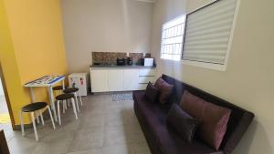 a living room with a couch and a kitchen at Aconchego Flats em Olímpia in Olímpia