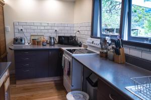 cocina con fregadero y fogones horno superior en Halfmoon Cottage en Akaroa