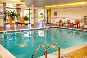 una piscina en un hotel con sillas y mesas en Courtyard by Marriott Richmond Northwest, en Henrico