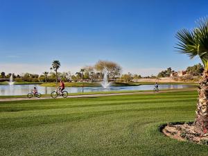 three people riding bikes in a park near a lake at Scottsdale Vacation Rentals in Scottsdale