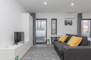 een woonkamer met een bank en een tv bij AveiNest - Your Studio in Aveiro in Aveiro
