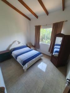 1 dormitorio con cama y espejo. en Casa Rural Doña Blanca en Samaipata