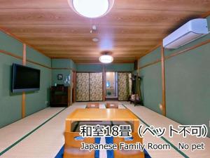 een kamer met een tafel en een flatscreen-tv bij Lodge Atelier in Hokuto