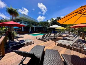 a group of chairs and umbrellas next to a pool at Old Crow Hotel and Suites in Vieques