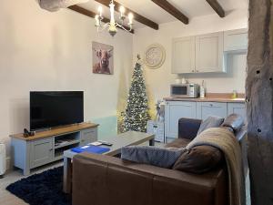 a living room with a couch and a christmas tree at Denver Cottage - Uk46029 in Monyash