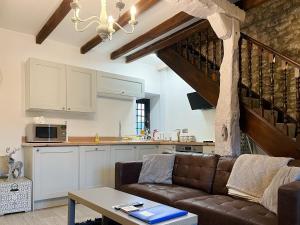 a living room with a couch and a kitchen at Denver Cottage - Uk46029 in Monyash