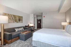 a hotel room with a bed and a couch at SpringHill Suites Terre Haute in Terre Haute +24 photos