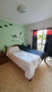 a bedroom with a bed with birds on the wall at La Mar in Mar de Ajó