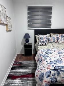 a bedroom with a bed and a lamp on a night stand at DARON HOMES in Brampton