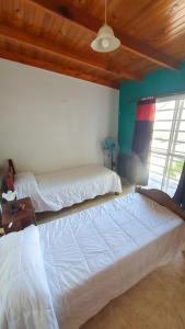 1 Schlafzimmer mit 2 weißen Betten in einem Zimmer in der Unterkunft La Mar in Mar de Ajó