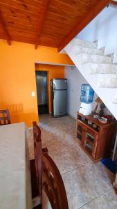 a kitchen with a refrigerator and a table and stairs at La Mar in Mar de Ajó